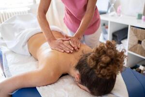 Woman getting spinal massage in clinic photo