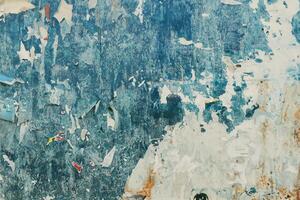 Torn poster paper surface as abstract grunge background, worn damaged printed billboard advertisement photo