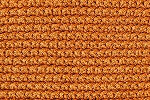 Orange knitted fabric texture background. Top view. Copy, empty space for text photo