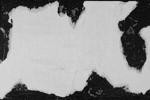 A sheet of white paper pasted on a black wall. photo