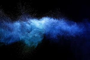 Abstract brown powder explosion. Closeup of blue dust particle splash isolated on black background. photo