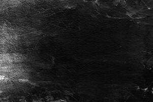 Old black stucco wall with white scratches and scuffs texture. textured grunge background for designers. photo