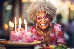 ai generado contento sonriente africano abuela en rosado lentes con pequeño cumpleaños pastel con velas foto