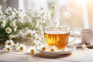 ai generado un vaso taza de herbario heathy manzanilla té en ligero de madera mesa con manzanilla flores en borroso antecedentes foto