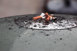 Ashtray with cigarette butts and ashes. Anti-smoking concept. photo