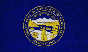 bandera de Nebraska estado Estados Unidos en un texturizado antecedentes. concepto collage. foto