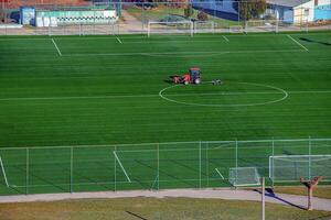 Top view on a tractor cares for the football field photo