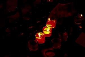 Prayer candles in votives, and insence, inside of a Catholic church photo