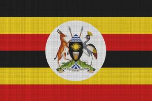 bandera y Saco de brazos de república de Uganda en un texturizado antecedentes. concepto collage. foto