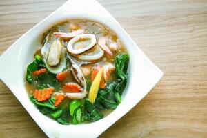 Wide Rice Noodles with Seafood in Gravy Sauce, or what we call Rad-Na Taley, served on a white plate in an Asian restaurant. photo