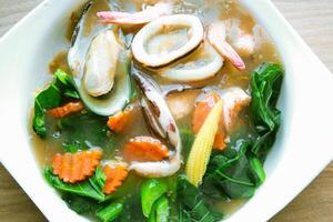 Wide Rice Noodles with Seafood in Gravy Sauce, or what we call Rad-Na Taley, served on a white plate in an Asian restaurant. photo