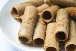 Crispy egg roll or crispy golden curl placed in a white plate, white background. Isolated. photo