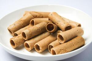 Crispy egg roll or crispy golden curl placed in a white plate, white background. Isolated. photo