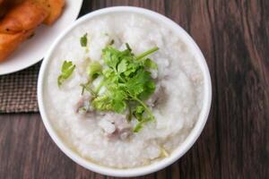 cerca arriba arroz gachas de avena , sopa de arroz con picado Cerdo y jengibre en blanco cuenco foto