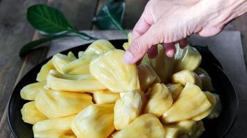 Thai fruit, fresh jackfruit placed in a black plate on a wooden table. photo