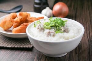 cerca arriba arroz gachas de avena , sopa de arroz con picado Cerdo y jengibre en blanco cuenco foto