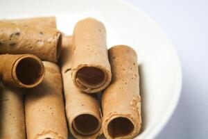 Crispy egg roll or crispy golden curl placed in a white plate, white background. Isolated. photo