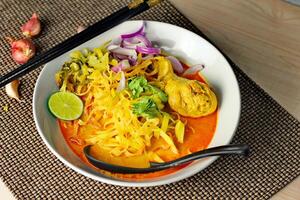 Khao soja receta, curry fideos sopa con pollo servido en blanco bol, tailandés alimento, curry fideos, tailandés fideos, del Norte alimento. foto