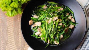 Stir-fried morning glory in a black dish Stir-Fried Morning Glory is also one of the most delicious dishes you can eat in Thailand. photo