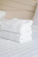 apilar de blanco toallas en cama en hotel foto