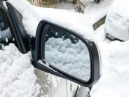 Close-up of a side mirror of a modern car covered in snow photo