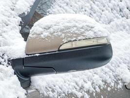 Close-up of a side mirror of a modern car covered in snow photo