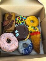 Multi-colored donuts in a box from the Voodoo Donut retail store in Portland. photo