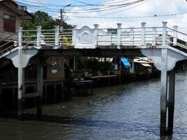 BANGKOK, THAILAND JULY 14, 2023 Vintage bridge at Khlong Bang Luang Floating market where is a famous landmark of Bangkok, Thailand. photo