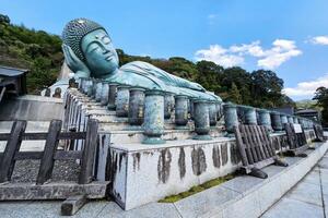 FUKUOKA, JAPAN NOVEMBER 14, 2023 Big Reclining buddha image at Nanzoin Temple where is landmark of Sasaguri, Fukuoka, Japan. photo