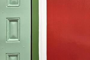 mínimo rojo pintura hormigón pared y madera verde puerta textura para antecedentes. foto