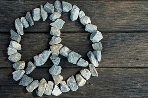 Peace Sign Stone on Wooden Table Background. photo