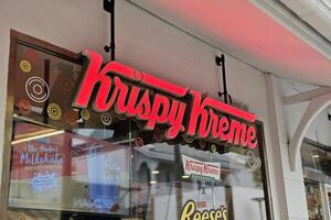 BANGKOK, THAILAND AUGUST 31, 2023 Krispy Kreme Doughnuts Sign. Krispy Kreme is an American multinational doughnut company that was founded July 13, 1937. photo