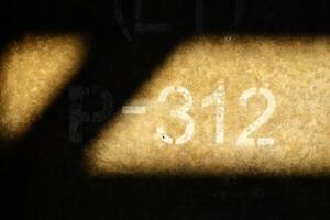 312 inscripción en hormigón pared con luz de sol haz. foto