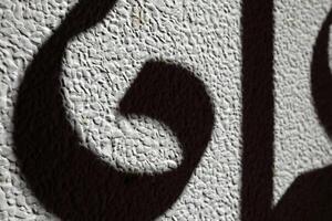 Abstract Fence Shadow on Sand Wall Background. photo