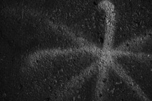 White Asterisk Sign on Black Grunge Concrete Wall Texture Background. photo