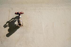 antiguo grifo en crudo hormigón pared con sombra, adecuado para mínimo concepto. foto