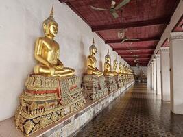 BANGKOK, THAILAND SEPTEMBER 13, 2023 Ancient Buddha Images in Cloister at Wat Mahathat Yuwaratrangsarit Temple. It is a Famous Landmark of Bangkok, Thailand. photo