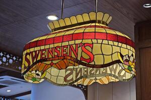 BANGKOK, THAILAND  OCTOBER 13, 2023 Vintage Stained Glass Ceiling Light with Swensens Name on the Lamp. Swensens was started in 1948 by Earle Swensen. photo