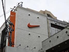 FUKUOKA, JAPAN  NOVEMBER 13, 2023 Nike sign on shop building at Tenjin. Nike, Inc. is an American famous athletic footwear, was founded in January 25, 1964. photo