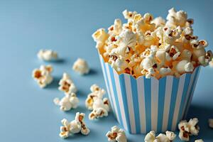 AI generated closeup striped paper box filled with delicious popcorn on a blue background photo