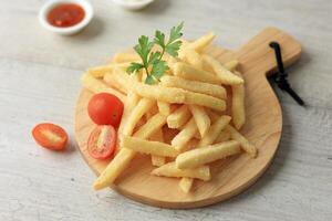 French Fries Served on Wooden Board Coating with Spice and Salt. photo