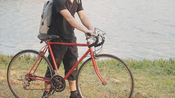 homme séance seul sur le de pointe de le colline avec vélo et prise image de le vue video