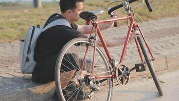 homme séance seul sur le de pointe de le colline avec vélo et prise image de le vue video