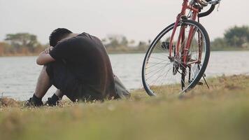 man sitting alone on the peak of the hill with bicyle and taking picture of the view video