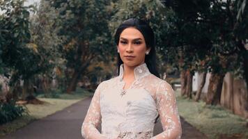 Elegant person in a lace gown posing on a tree-lined path video