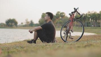 Mann Sitzung allein auf das Gipfel von das Hügel mit Fahrrad und nehmen Bild von das Aussicht video