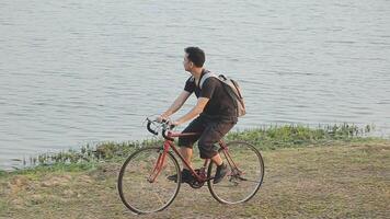 man sitting alone on the peak of the hill with bicyle and taking picture of the view video