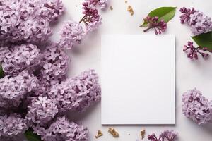 AI generated mockup white blank paper sheet with lilac flowers top view on white background, floral template empty card flat lay for design with copy space photo