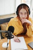 Female podcaster making audio podcast from her home studio photo