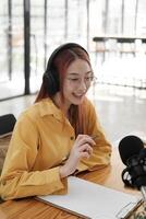 Female podcaster making audio podcast from her home studio photo